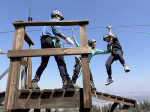 Monitores recibiendo a una persona despues de participar en actividad de la tirolesa