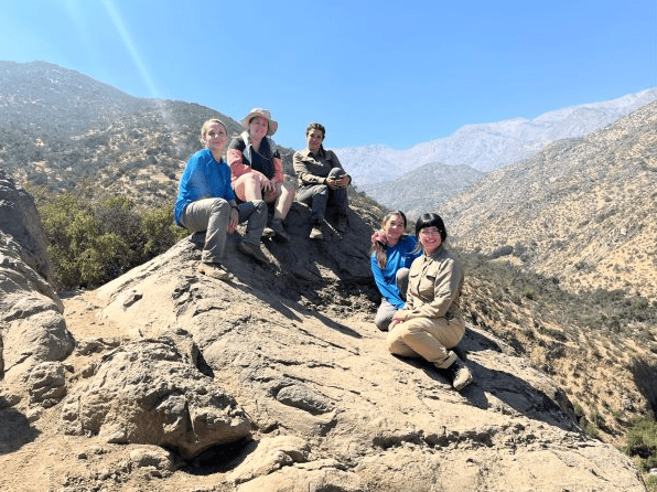 Grupo de monitoras y guardaparques posando encima de una roca en Parque Natural Aguas de Ramón